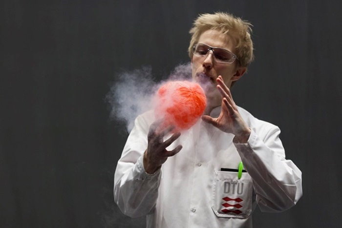 A shrunken, refrigerated balloon is expanding to normal size because a presenter blows hot air on it. Photo: Thomas Hjort Jensen